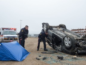 Cst. Raymond Robertson, left, and Cst. Patrick Foster, both of the Saskatoon Police Service, demonstrate a walkthrough of a mock crash scene during an SGI news conference held at the SGI salvage centre in Regina on Oct. 30, 2020.