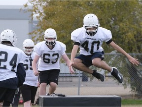 Layne Ermel, 40, takes part in a drill during a Thom Trojans football practice. David Francis, 63, is next in line.