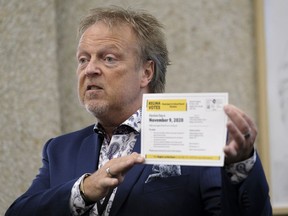Jim Nicol, chief returning officer for Regina's 2020 municipal/school board elections, shows off a voter information card during a press conference.