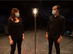 Tour guides Robyn Sanderson, left, and Aren Okemaysim stand near a "ghost light" on the main stage at the Globe Theatre.