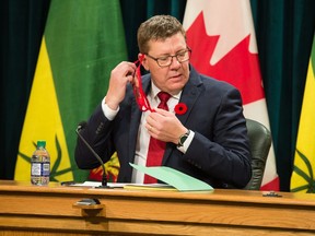 Saskatchewan Premier Scott Moe removes his mask prior to a news conference at the Legislative Building on Nov. 3, 2020.
