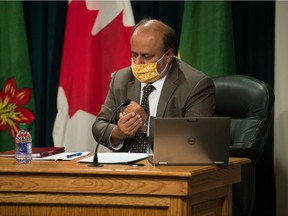 Saskatchewan's chief medical health officer Dr. Saqib Shahab sanitizes his hands during a news conference regarding COVID-19 at the Saskatchewan Legislative Building in Regina, Saskatchewan on Nov 17, 2020.