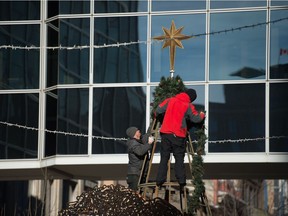 Workers install Christmas decorations on Scarth Street in Regina, Saskatchewan on Nov 18, 2020.