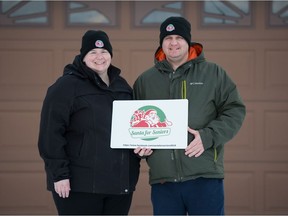 Brenda Louvel, left, and her husband Sean Louvel stand in front of their home in Regina, Saskatchewan on Nov. 20, 2020. The pair are directors of Santa for Seniors South Saskatchewan, which buys and delivers Christmas presents for seniors in care homes.