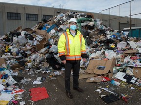 Crown Shred and Recycling general manager Anatoly Davidian stands in front of contaminated material which the company cannot recycle, piled in the company's yard in Regina, Saskatchewan on Nov. 26, 2020.