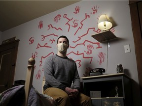 Mitch Bresciani, co-owner and manager of Mystery Mansion Escape Rooms, sits on a bed in the Night Terrors room. The business offers online only escape rooms to a global audience.