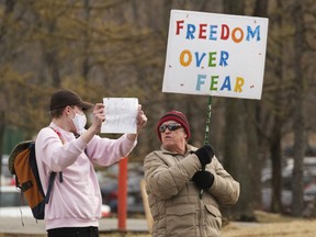 A mask supporter stands beside an anti-mask supporter during an anti-mask rally near the MacKenzie Art Gallery.