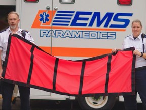 Daniel Lewis (left), program development educator for EMS in Regina, and paramedic Dana West hold up one of the new EMS lift sheets, designed to make it easier for paramedics to lift patients.