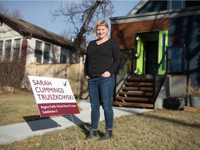 Charity Marsh stands in front of her house in Regina on Nov. 2, 2020, next to a lawn sign supporting Regina Public School Board candidate Sarah Cummings Truszkowski.
