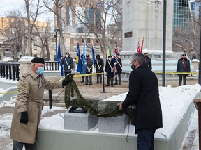 Maj. (retd) Brad Hrycyna, left, and Saskatchewan Lt.-Gov. Russ Mirasty unveil plaques, which provide context to Canada's wartime sacrifices, during an unveiling ceremony held at Victoria Park in Regina on Nov 10, 2020.
