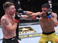 In this handout image provided by UFC, Rafael Dos Anjos, right, punches Paul Felder, left, in a lightweight fight during the UFC Fight Night event at UFC APEX in Las Vegas, Saturday, Nov. 14, 2020.