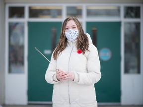 Samantha Ranger, a band teacher with Regina Catholic School Division, stands holding her conductor's baton outside of St. Timothy School in Regina, Saskatchewan on Nov. 10, 2020.