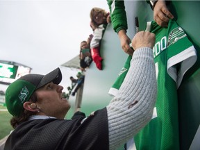 Saskatchewan Roughriders quarterback Cody Fajardo, shown signng a jersey for a fan at Mosaic Stadium in 2019, is now obligated to the CFL team through the 2022 season.