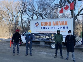 Sandeep Singh Sandhu, from left, Gagandeep Singh, Amarjot SIngh Sahota

and Hem Singh Jutla stand in front to the  Guru Nanak Free Kitchen truck on Monday, November 30, 2020.