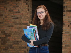Caralyn Engbers, founder of Books for Community Schools and a Grade 12 student at Regina Christian School, stands outside her Regina home with some of the donated books she has collected on Dec. 5, 2020.