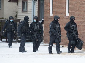 Police officers leave a home on the 1500 block of Bond Street following a police operation in Regina, Saskatchewan on Dec. 17, 2020.