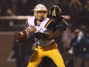 Keion Adams, right, of the Western Michigan Broncos hits quarterback Logan Woodside of the Toledo Rockets and causes a fumble during an NCAA football game on Nov. 25, 2016.