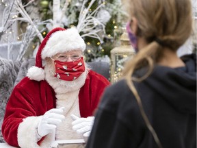 A socially distanced Santa Claus speaks to a youngster at the Victoria Square Shopping Centre.