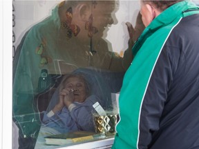 Brian Albert, right, looks into his mother Marie Albert's window at Extendicare Parkside in Regina on Dec. 15, 2020.