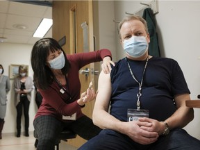 Heather Witzel-Garnhum, nurse clinician, injects Dr. Jeffrey Betcher, critical care lead, with the Pfizer-BioNTech COVID-19 vaccine at the Regina General Hospital on Dec. 15, 2020.