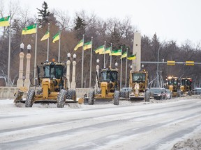 Graders move snow on the Albert Street Bridge in Regina, Saskatchewan on Jan. 14, 2020. City resources are focused on opening up main arteries of travel before heading to residential areas, according to the city.