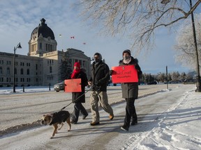 From left, Krystal Kolodziejak, her husband Nathan Brenner walking dog Jeter, and her sister Adynea Russell walk together as part of a "virtual" Women's March at near the Saskatchewan Legislative Building in Regina, Saskatchewan on Jan. 16, 2021. Those wanting to participate in the annual march this year were asked to walk in their own neighbourhoods, as a group gathering was not possible due to COVID-19.