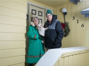 Jessie Carlson, shown on left holding dog Zach, and Gary Carlson stand outside their home in Regina, Saskatchewan on Jan. 23, 2021. Until recently, their home doubled as the Daybreak Bed and Breakfast.