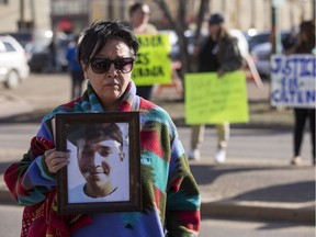 Colten Boushie's mother Debbie Baptiste holds a photo of her son outside of North Battleford provincial court at Gerald Stanley's preliminary hearing in North Battleford on April 6, 2017