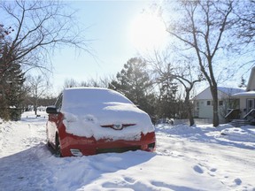 A snow covered car sits on a street in Cathedral.