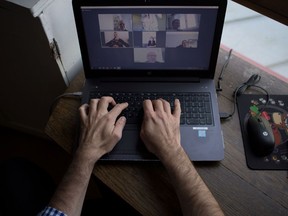 A man takes part in a video conference as he works from home.