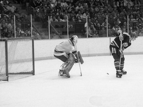 Wayne Gretzky of the Edmonton Oilers deflects a puck between his legs in front of St. Louis Blues goaltender Mike Liut during NHL pre-season action Sept. 30, 1981 at the Agridome in Regina.
