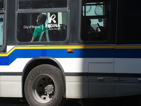 A man wearing a mask sits on a city transit bus in downtown Regina, Saskatchewan on August 24, 2020.