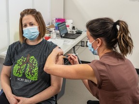 Respiratory therapist Karen Schmid receives the Pfizer Covid-19 vaccine from registered nurse Lianne Korte, becoming the first person in Saskatoon to receive the vaccine. Photo taken in Saskatoon, SK on Tuesday, December 22, 2020.