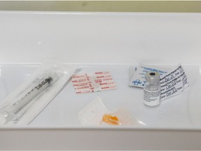 A vial of the Pfizer Covid-19 vaccine rests in a tray with a syringe and sterilization materials at Merlis Belsher Arena.