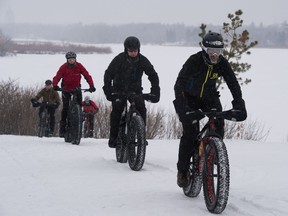 Members of the Offroad Syndicate Mountain Bike Club ride their bicycles near Wascana Lake in Regina, Saskatchewan on Jan. 30, 2021.