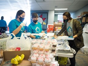 From left, Chasity Delorme, Cara Spence and Cody Lloyd fill styrofoam containers with food for memorial feast for Derrick Sasakamoose, which was held at the Awasiw Warming Shelter on 5th Avenue in Regina, Saskatchewan on Feb. 13, 2021.