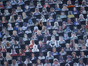 February 7, 2021, A woman surrounded by cut-out photographs of fans to maintain social distancing due to COVID-19 takes a photograph with her cell phone before the game