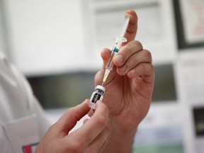 A medical worker draws the Pfizer-BioNTech COVID-19 vaccine from a vial at the Max Fourastier hospital in Nanterre, France, Jan. 5, 2021.