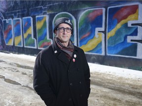 Paul Dechene poses for a photo by a mural in the Cathedral Village area of Regina.