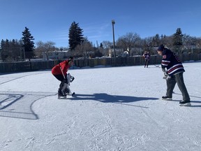 Rob Vanstone, right, skates in on goaltender Rod Pedersen during a shinny game on Feb. 20 at the Lakeview outdoor rink.