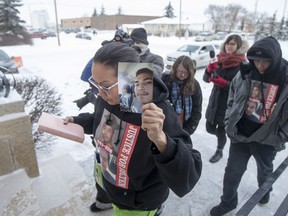 Debbie Baptiste holding a photograph of he son of Colten Boushie enters Battleford Court of Queen's Bench at the start of day four of the Gerald Stanley second degree murder trial of the shooting death of Colten Boushie in Battleford, SK on Friday, February 2, 2018.