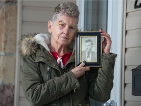 Beverley Hartnell holds a photo of her father, Bernard Hartnell, in front of her home in Regina, Saskatchewan on Feb. 2, 2021. Bernard was a resident at Santa Maria Senior Citizens Home until he died of COVID-19 in January 2021.