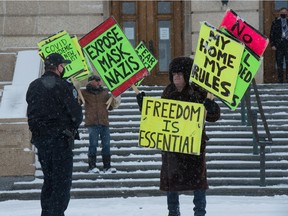 An anti-mask demonstrator has words with a peace officer at the Saskatchewan Legislative Building in Regina, Saskatchewan on Mar. 9, 2021. Police say the majority of interactions are peaceful, but their enforcement targets leaders and organizers as a means of deterrence.
