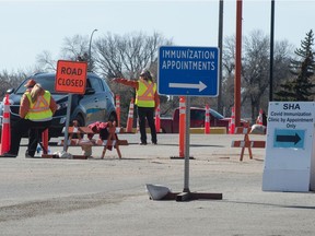 Motorists are directed to the COVID-19 vaccine lineup at Evraz Place in Regina, Saskatchewan on March 19, 2021.