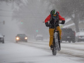 Evan Neufeldt braves the storm for a bike ride through heavy winds and snow on Monday, March 29, 2021.