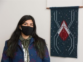 Artist Audie Murray stands next to her piece entitled Spider in the Cosmos, on March 2, 2021. The piece is part of an exhibition featuring her work at the Neutral Ground art gallery on Scarth Street in Regina.