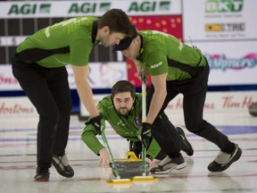 The Matt Dunstone team from Saskatchewan curls against Team Wild Card 3 in championship-pool play at the Brier in Calgary on March 12, 2021. Kirk Muyres, left, and Dustin Kidby are the sweepers. Michael Burns/Curling Canada.