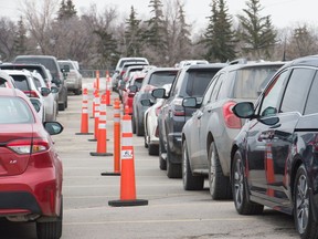 Motorists wait for COVID-19 testing last week on the Evraz Place grounds.