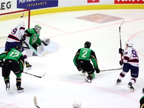 Regina Pats' Connor Bedard, right, scores his second WHL goal — in his first WHL game — on Friday by putting one past Prince Albert Raiders goaltender Max Paddock at the Brandt Centre.