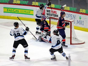 Regina Pats vs. Winnipeg Ice on March 23, 2021 at the Brandt Centre. Jakin Smallwood (left) and Zach Benson (right) of the Ice celebrate a goal against Regina netminder Roddy Ross. Pats defenceman Jake Johnson (28) is also shown. Keith Hershmiller Photography.